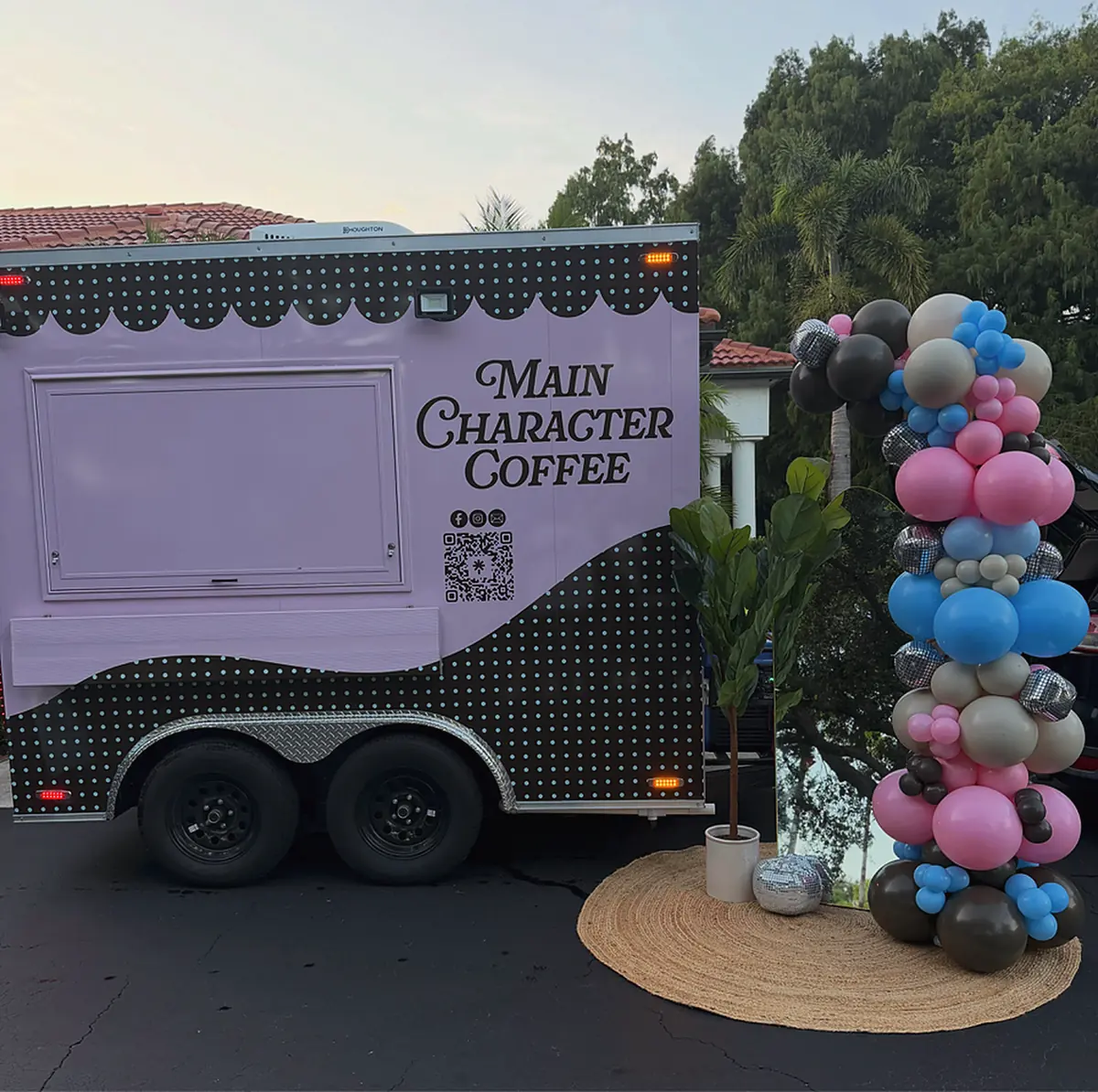 Balloon column with disco balls beside a lavender coffee trailer